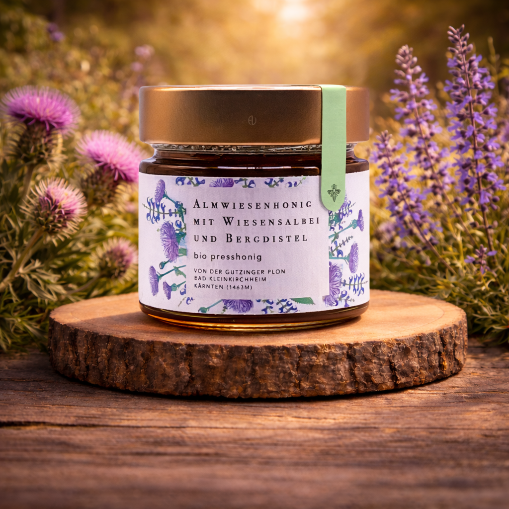 Bio Almwiesenhonig Presshonig aus Österreich mit Wiesensalbei und Bergdistel im Glas auf Holzscheibe, warmes goldenes Licht, hochwertige Natur-Produktfotografie online kaufen