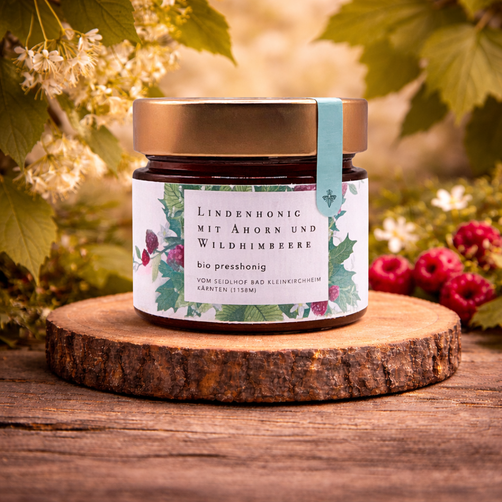 Bio Lindenhonig Presshonig aus Österreich mit Ahorn und Wildhimbeere im Glas auf Holzscheibe, Lindenblüten und Beeren, warmes Naturlicht, Premium Honig online kaufen